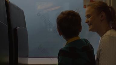 小男孩妈妈。坐着窗口铁路火车的地方看运费火车